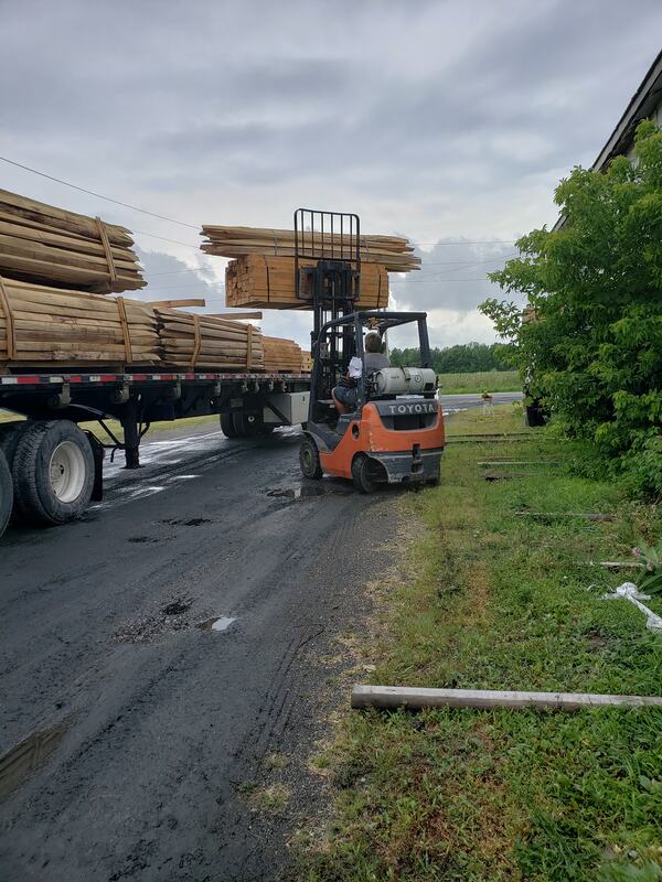 Forklift unloading fence wood from lumber truck